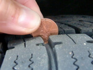 car tyre maintenance, checking car tyre thread with coin